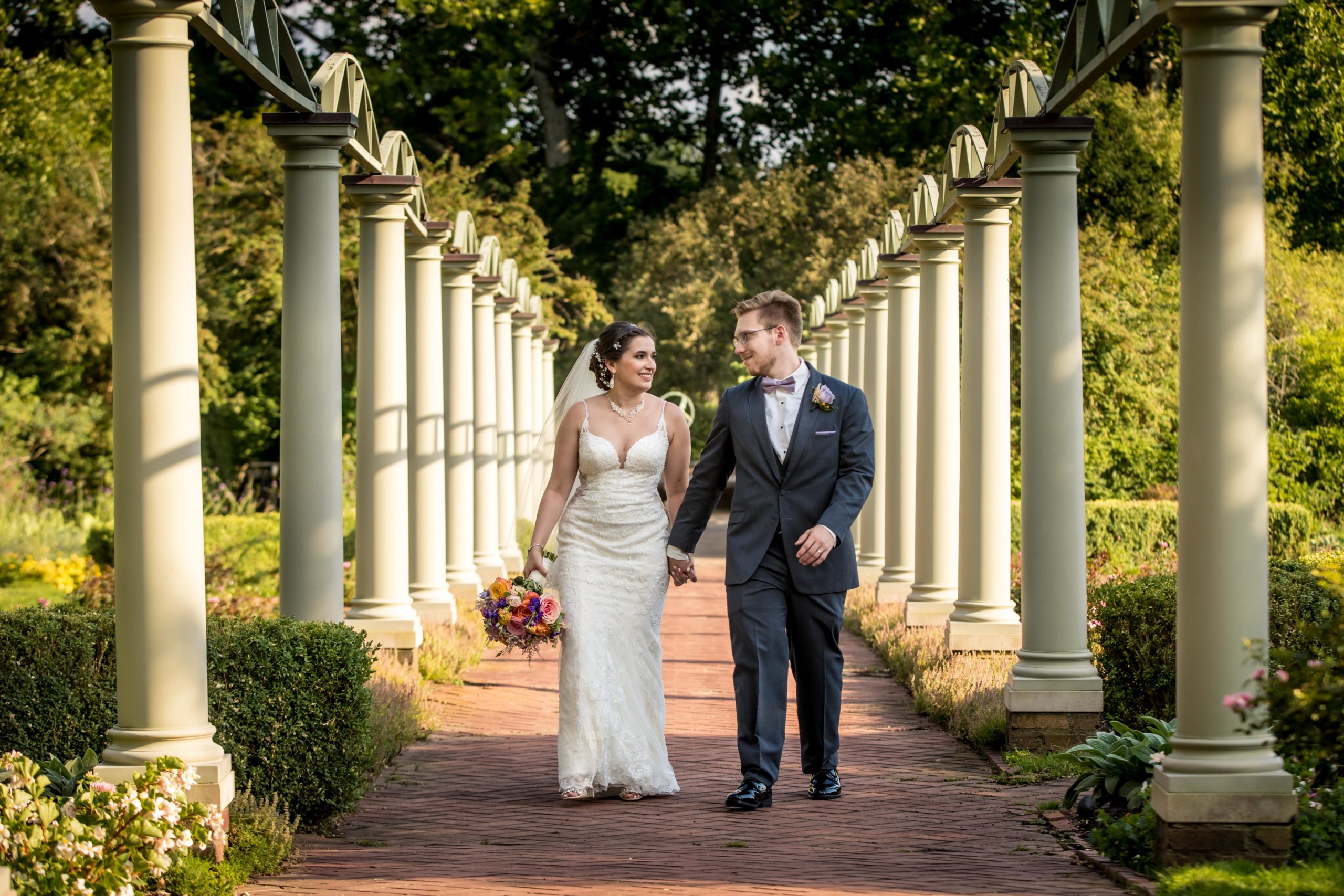 bride and groom walking in meadow brook garden