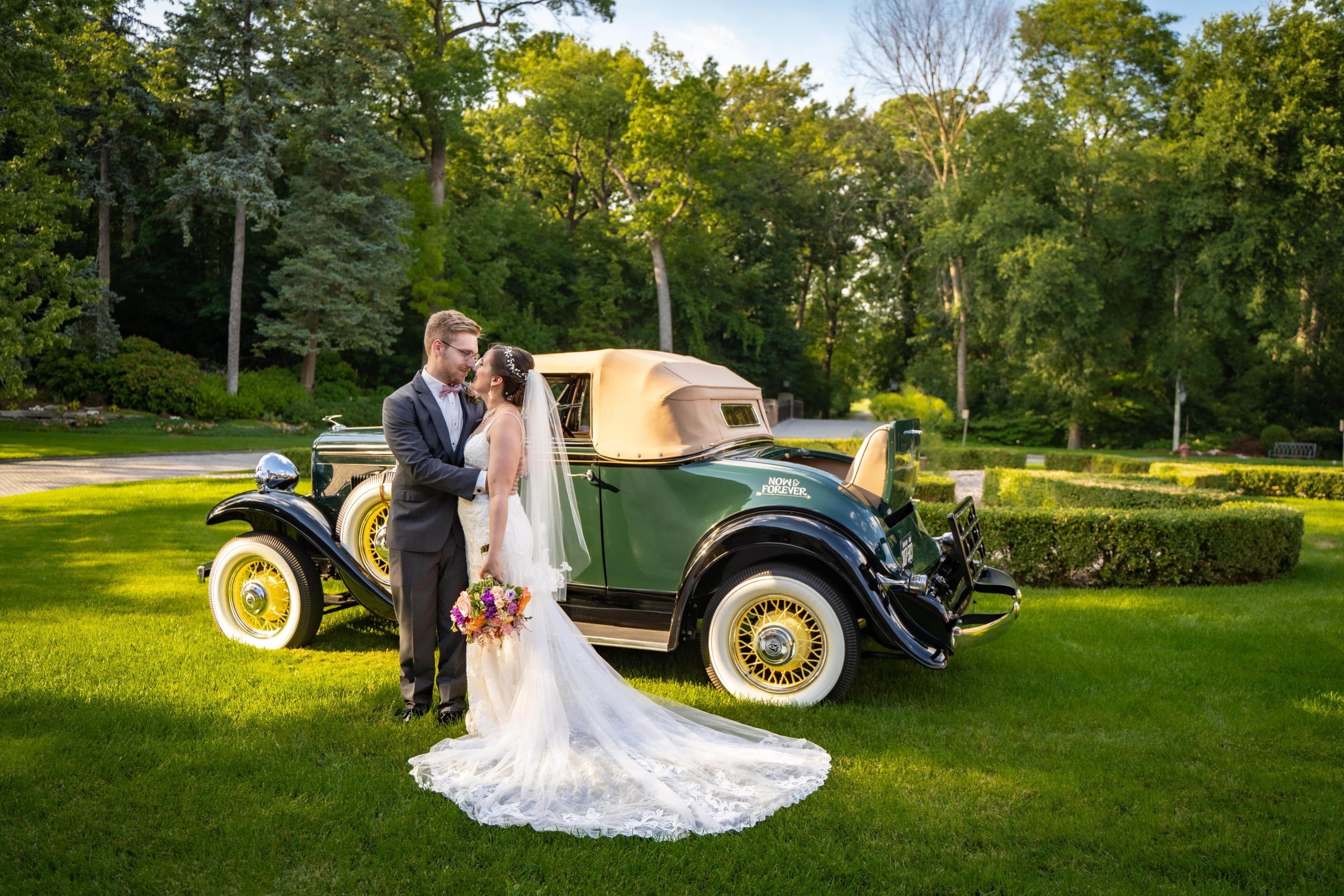 bride and groom in front of classic car