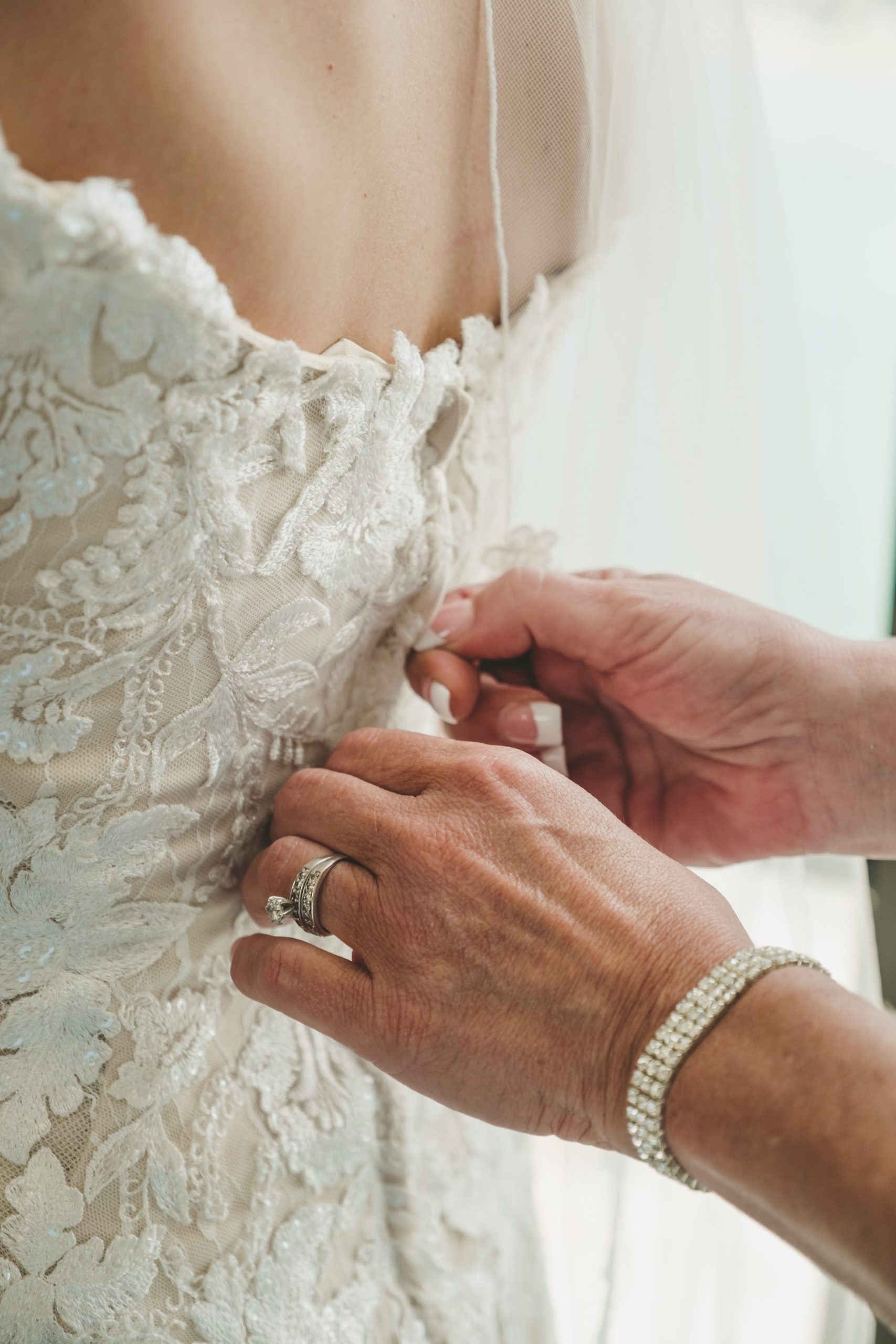 mother of bride zipping bride's gown