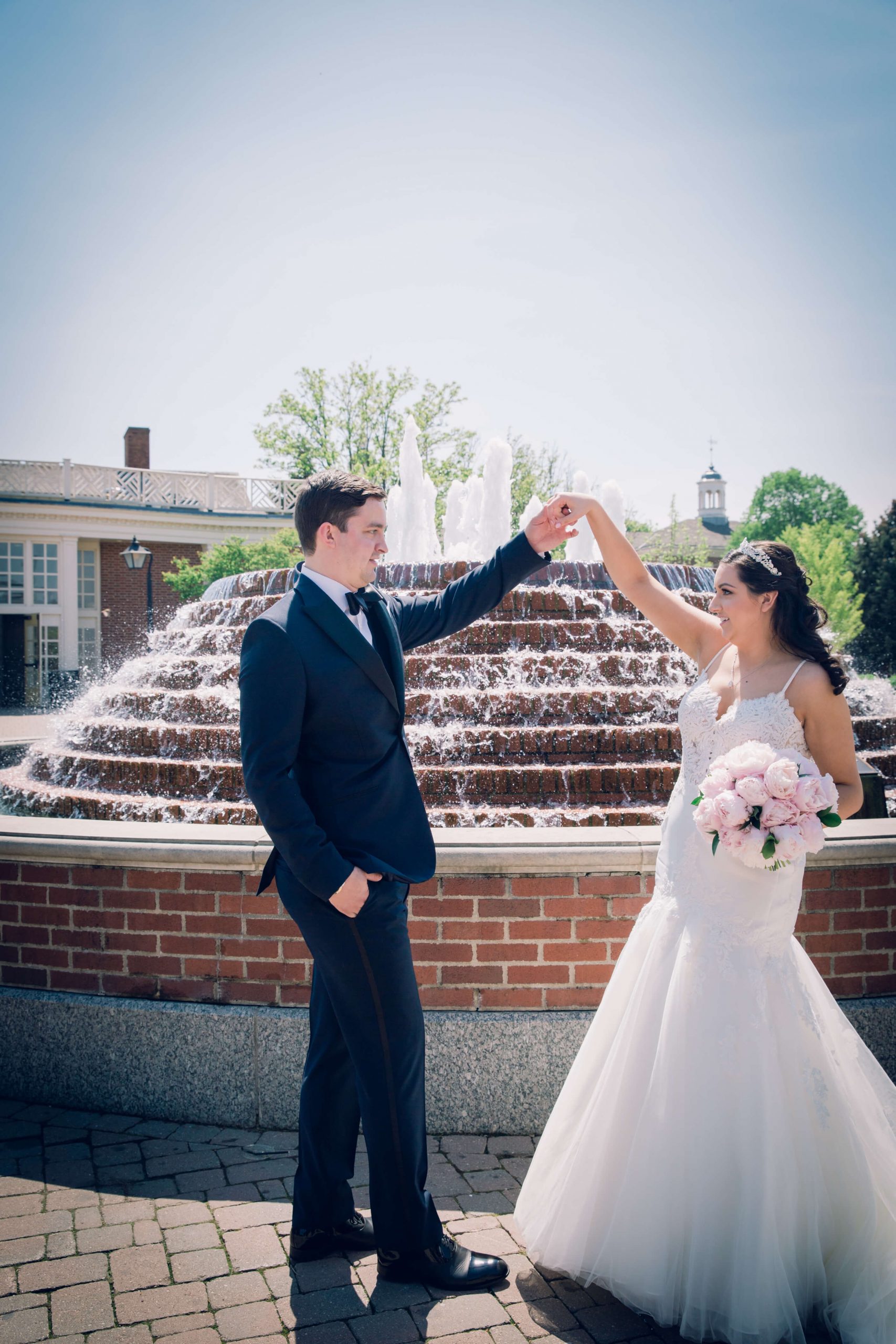 bride and groom dancing in front of fountain