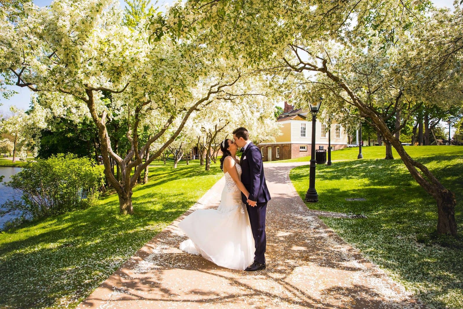 bride and groom kissing on path at greenfield village