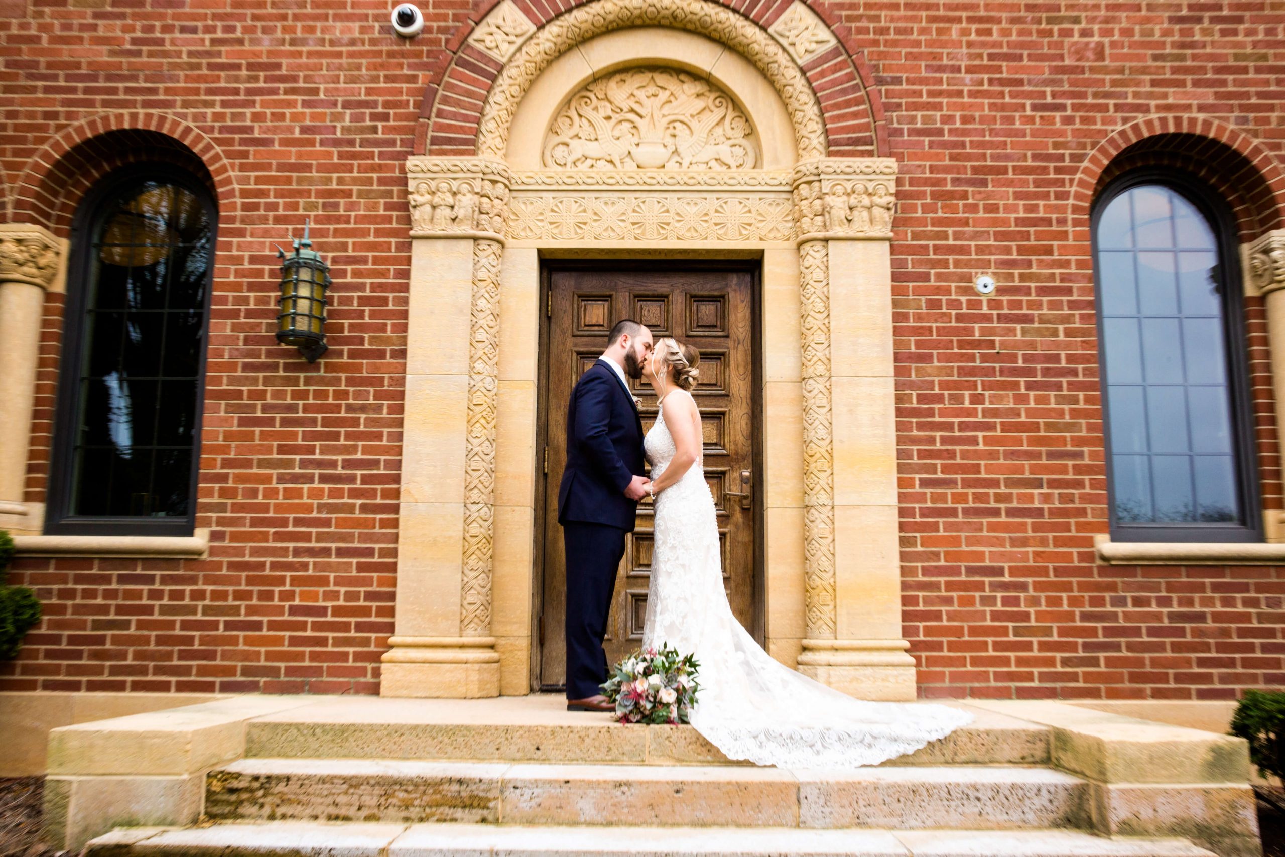 bride and groom kissing outside inn at st. john's