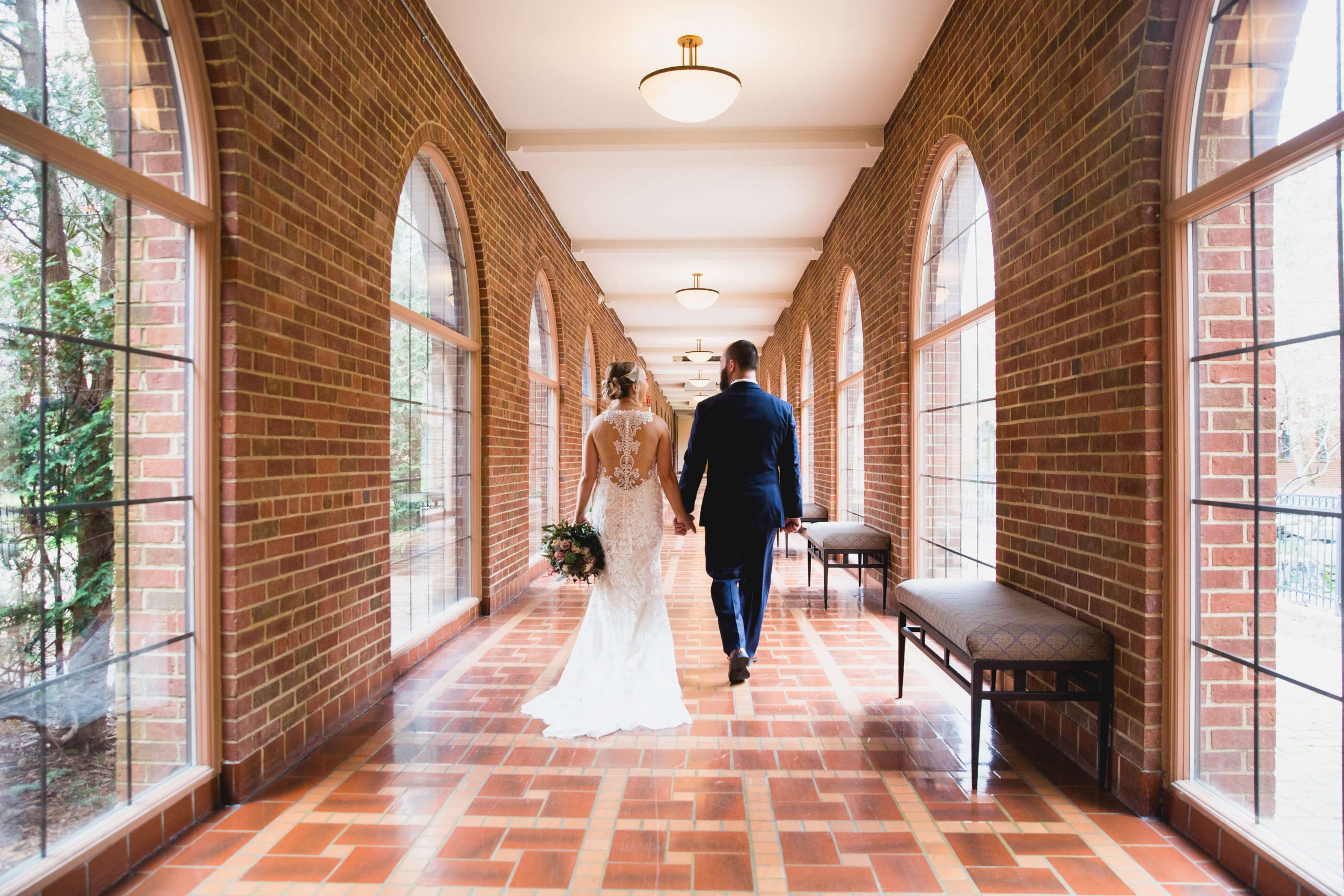 bride and groom walking down hall at inn at st. john's