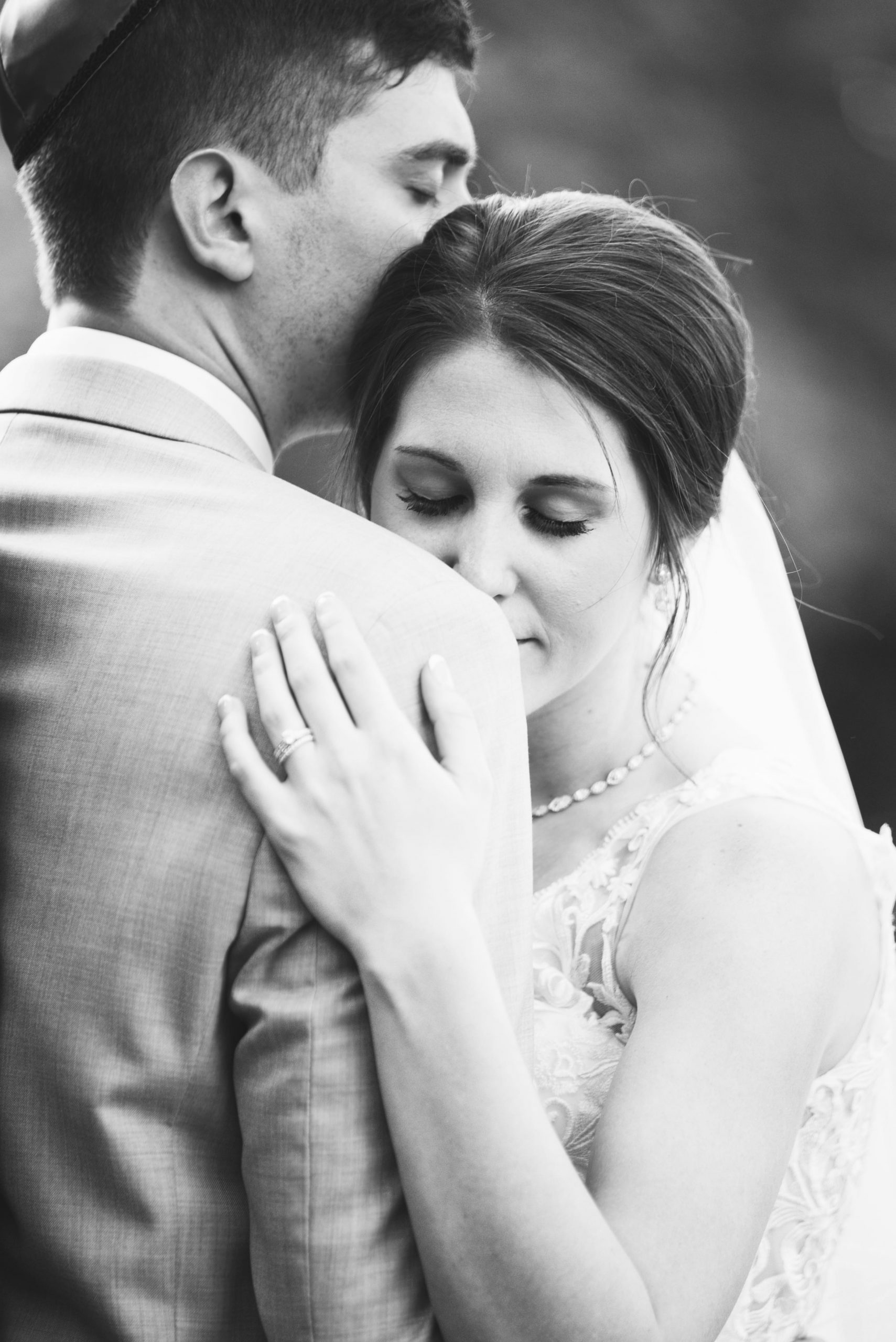 black and white photo of bride leaning on groom's shoulder