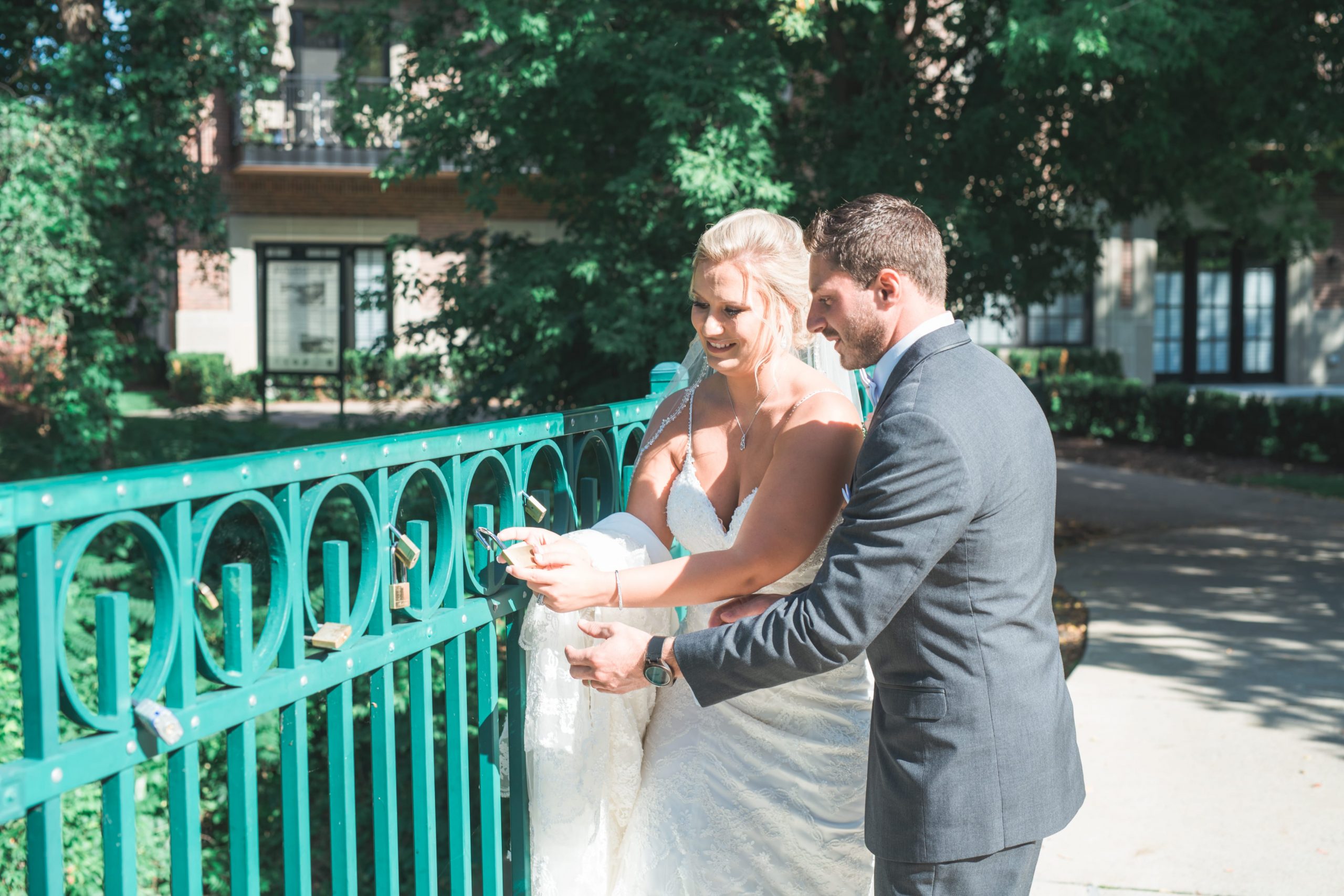 bride and groom putting lock on a fence