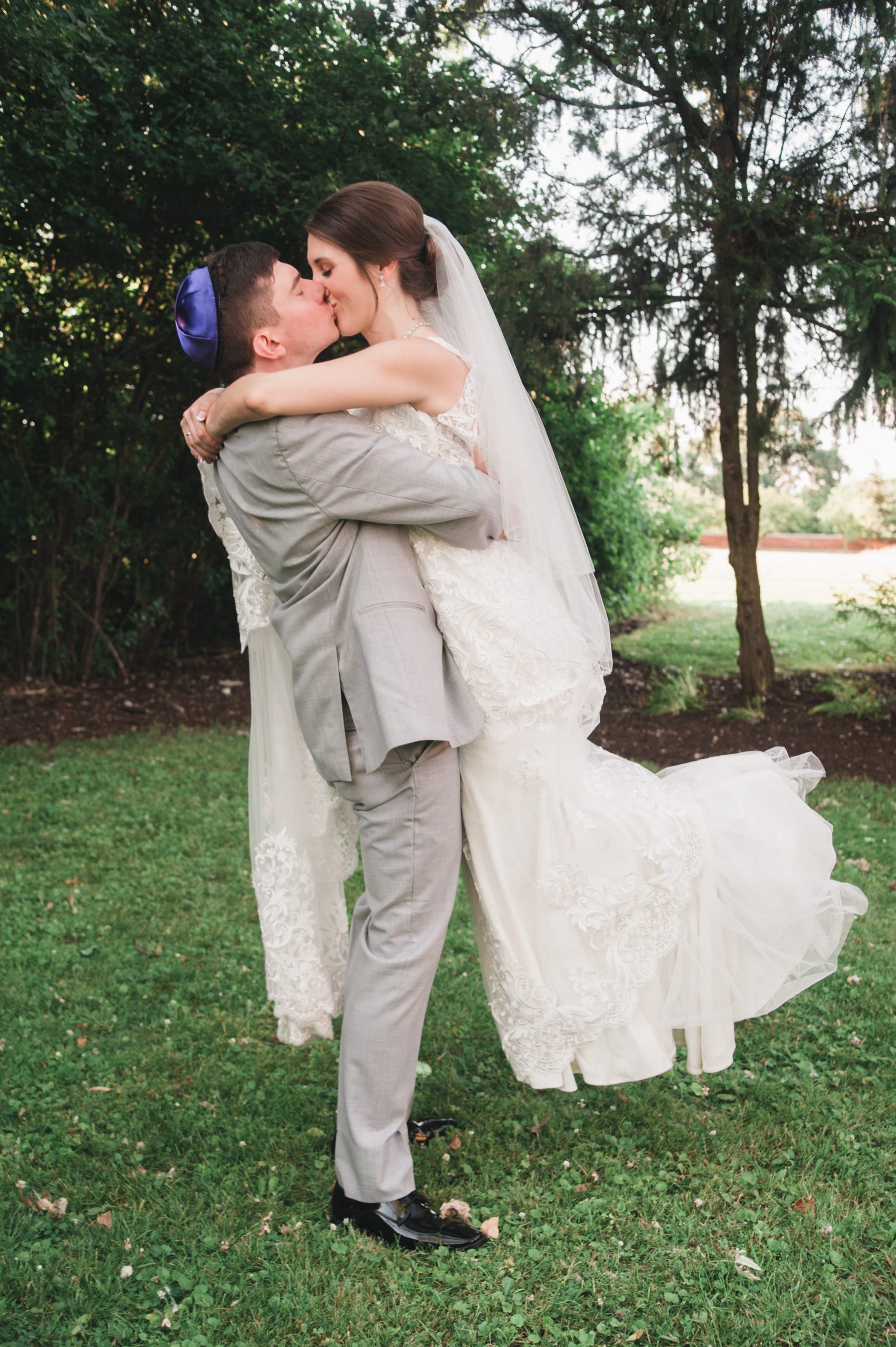 groom lifting bride in air to kiss her