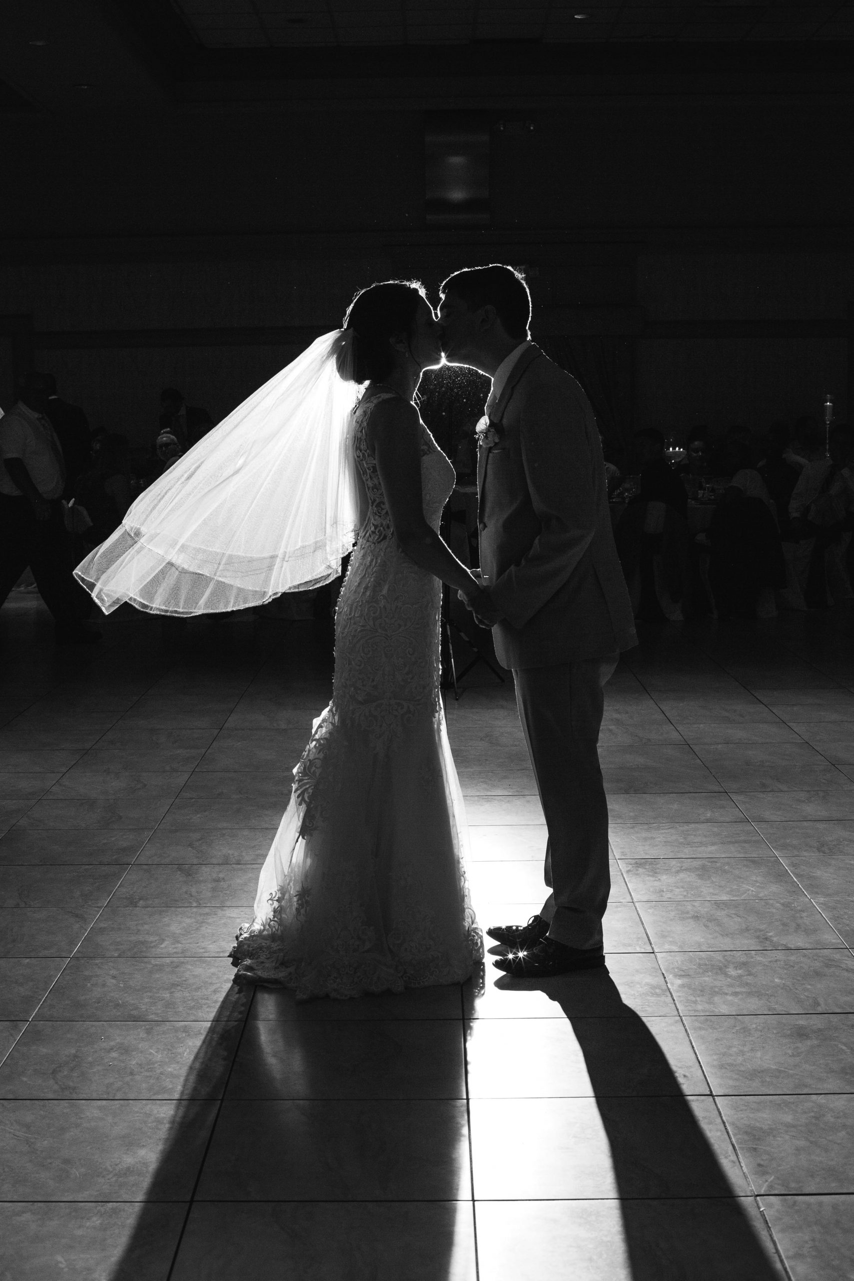 bride and groom kissing on dancefloor with spotlight