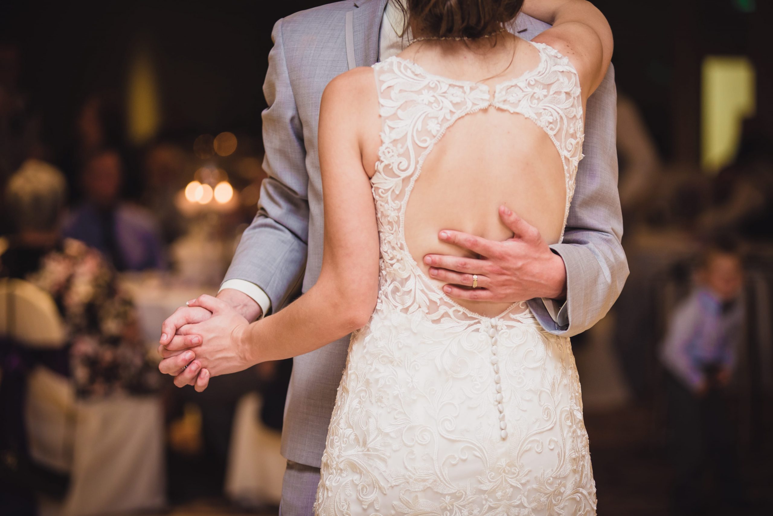 bride and groom dancing, with groom's hand on bride's back