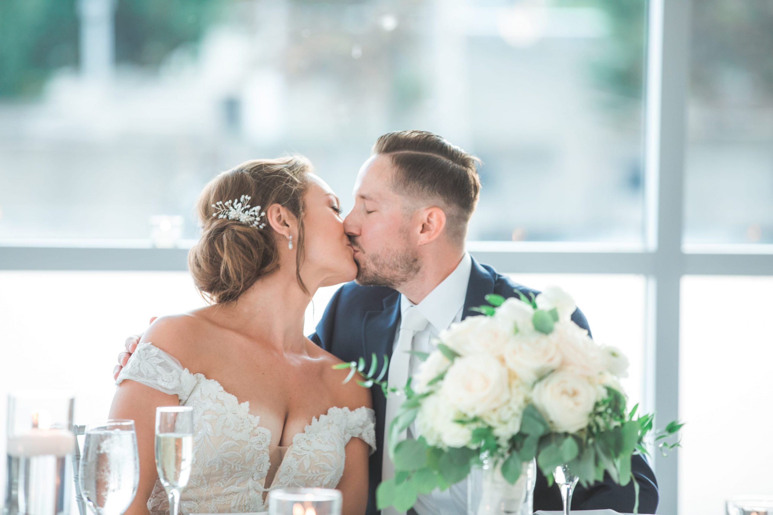 bride and groom kissing at head table