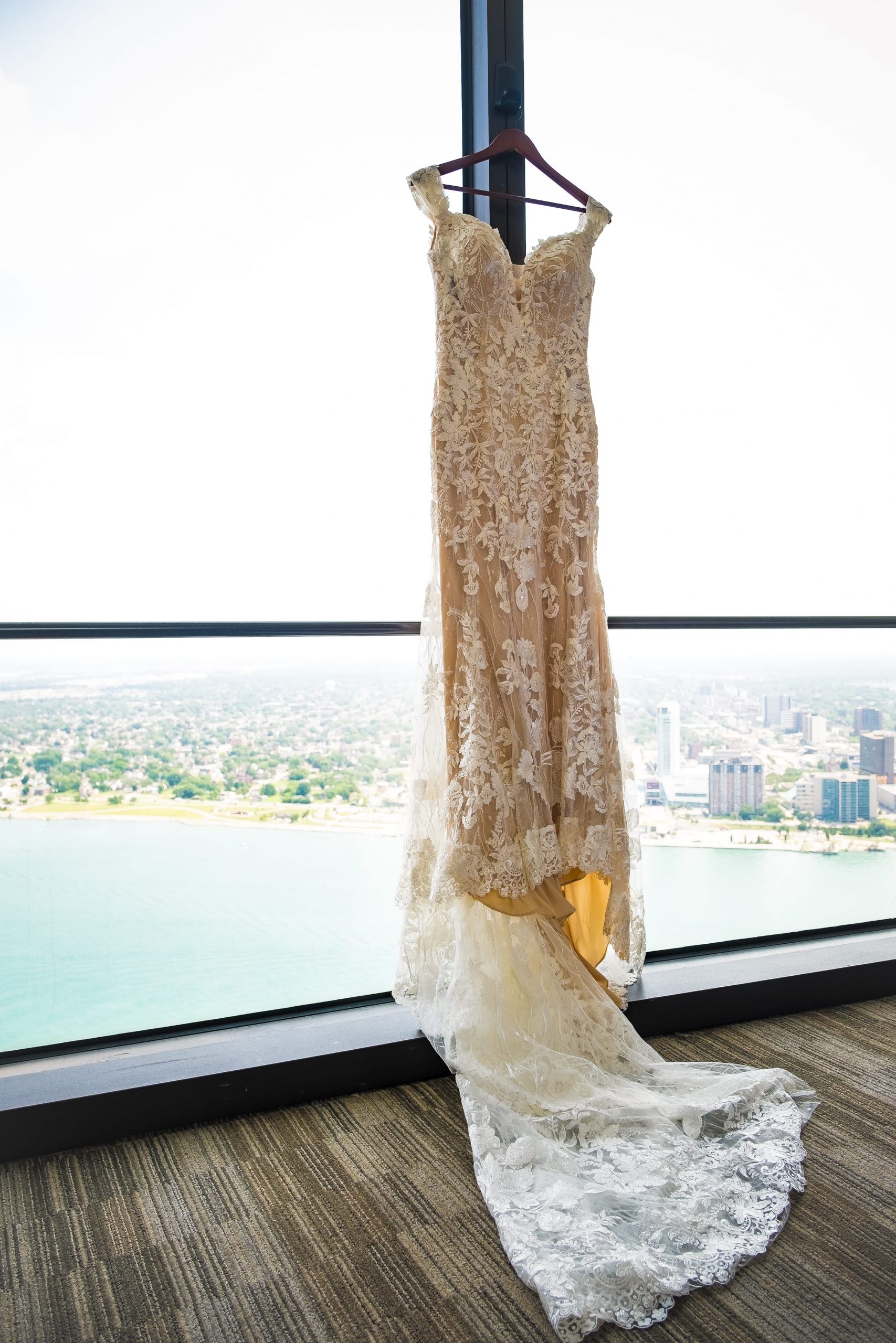 bride's gown hanging on window at detroit waterfront