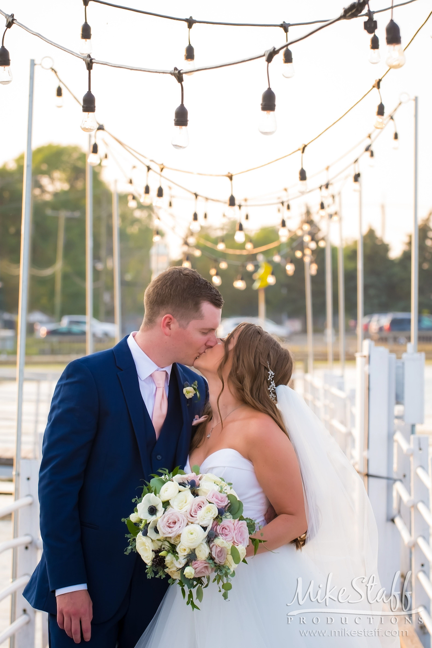 bride and groom kissing at roostertail