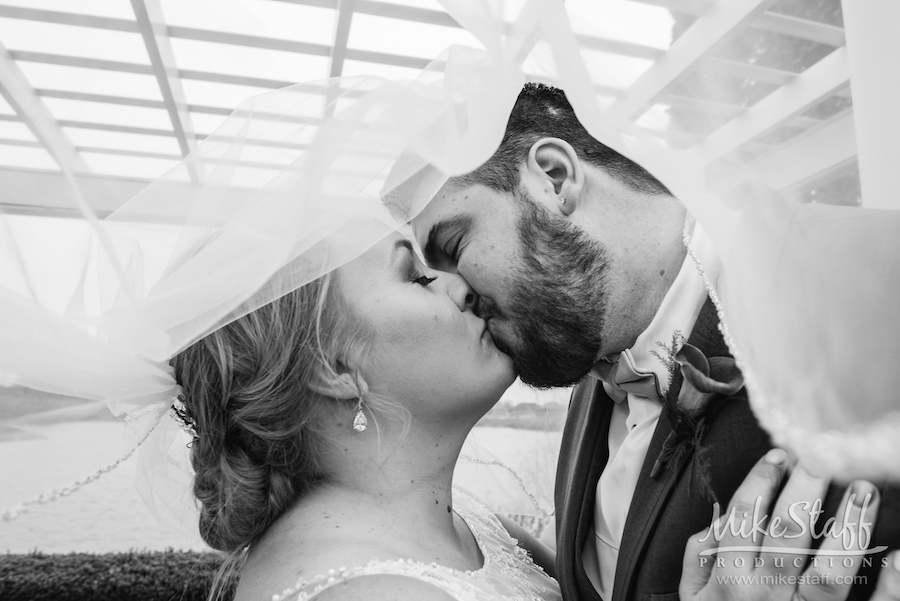 bride and groom kissing under veil