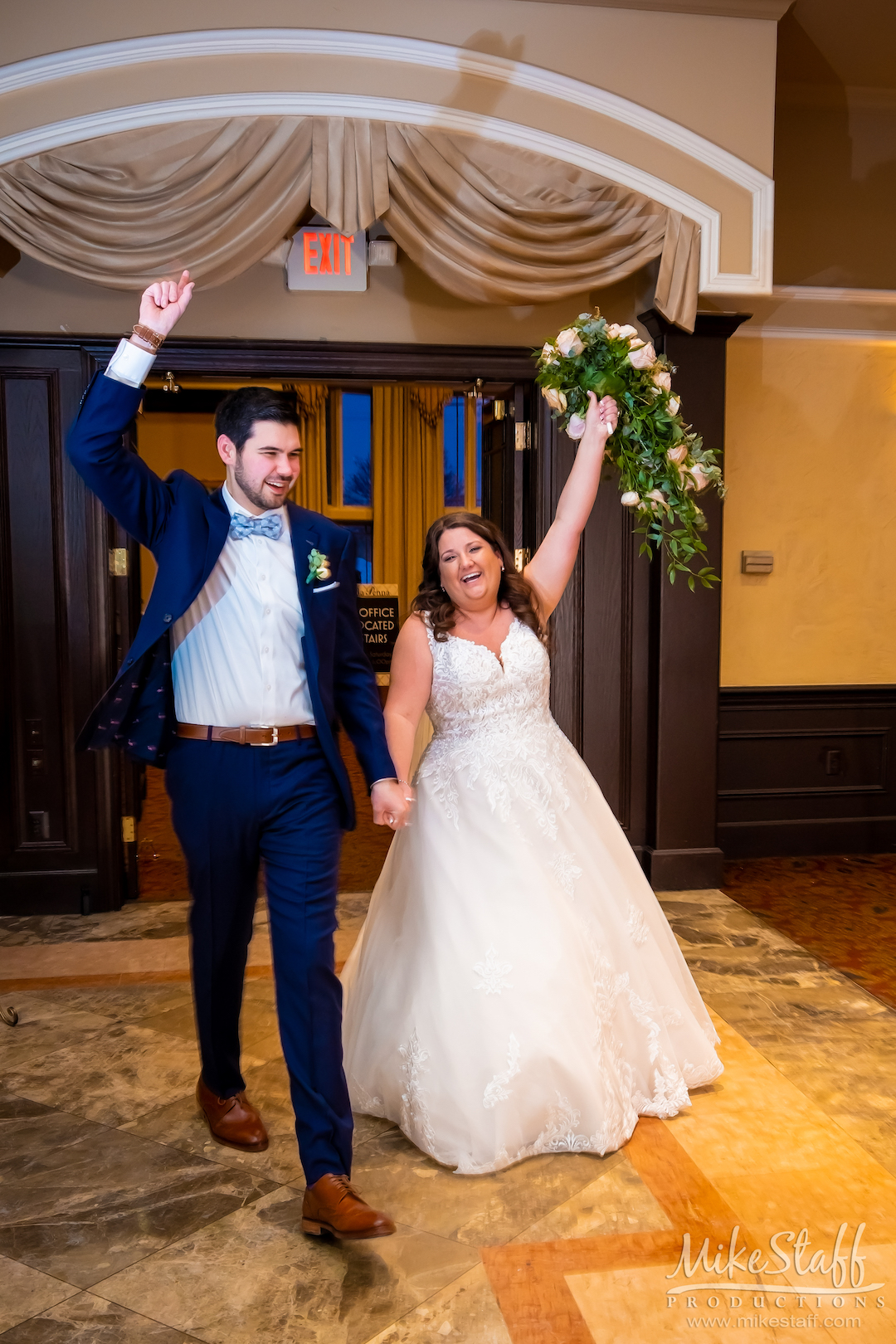 bride and groom walking into reception