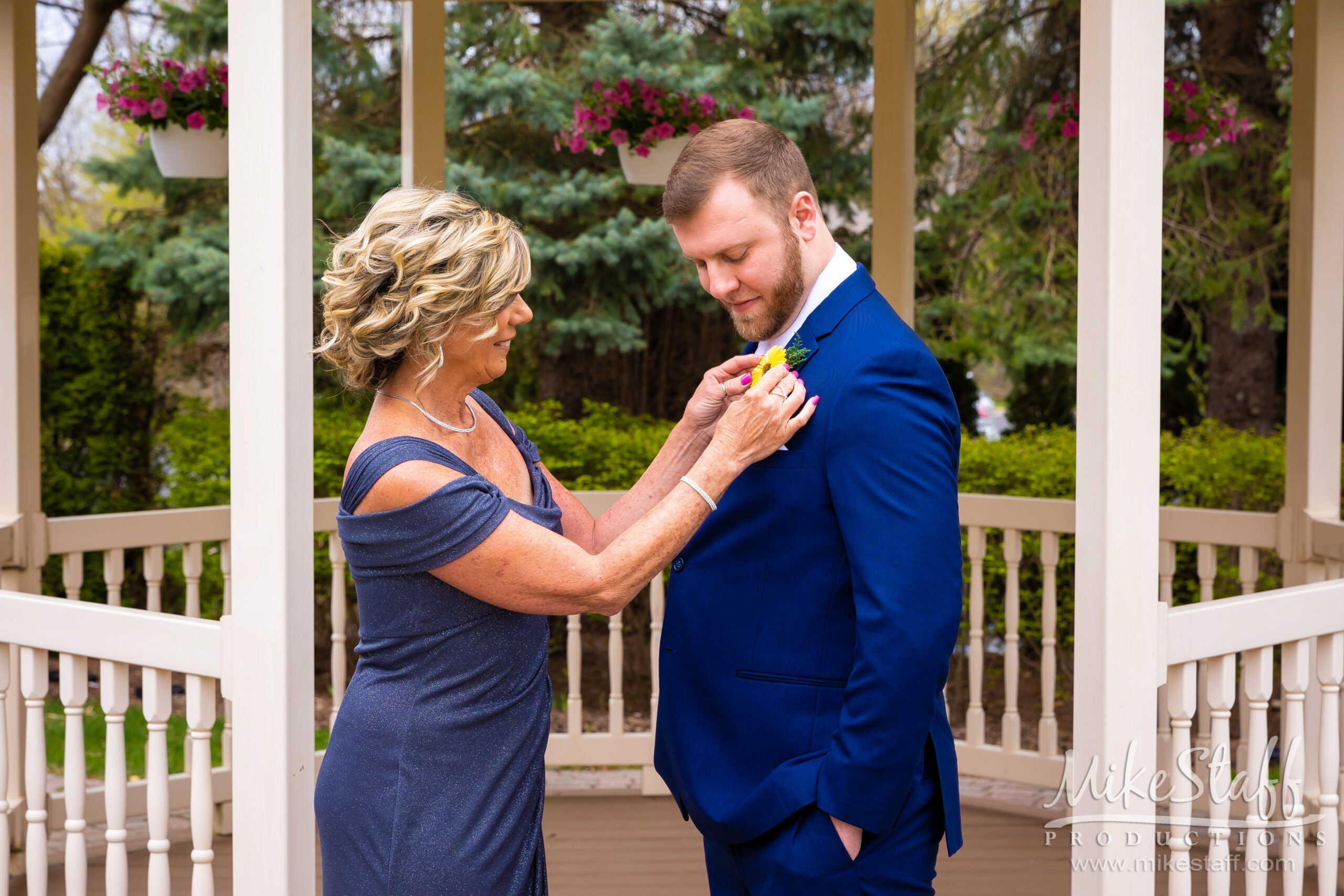 groom and mother pinning boutineirre