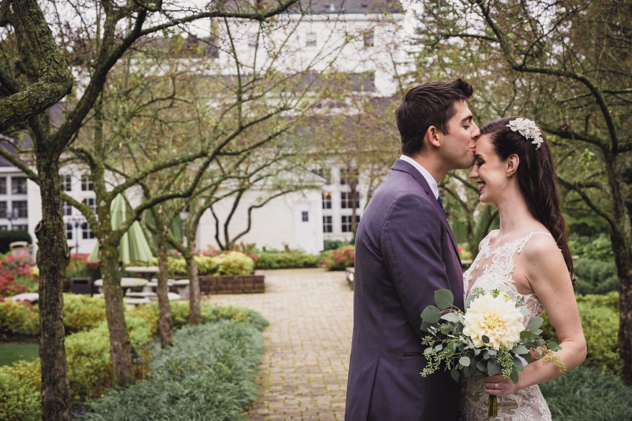 groom kissing bride on forehead