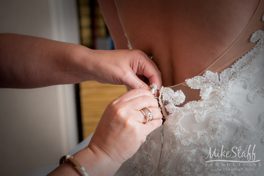 pre-ceremony bride getting dress on