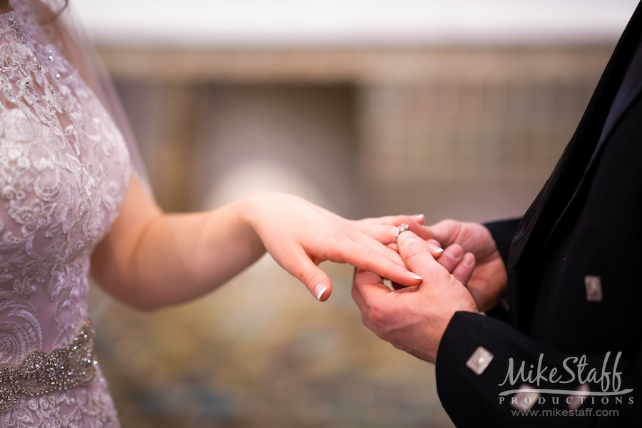 groom putting wedding band on bride abby and garret