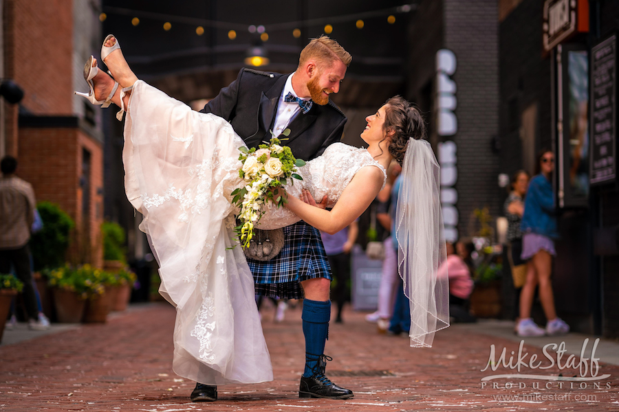 the belt downtown groom garret picking up bride feet in the air