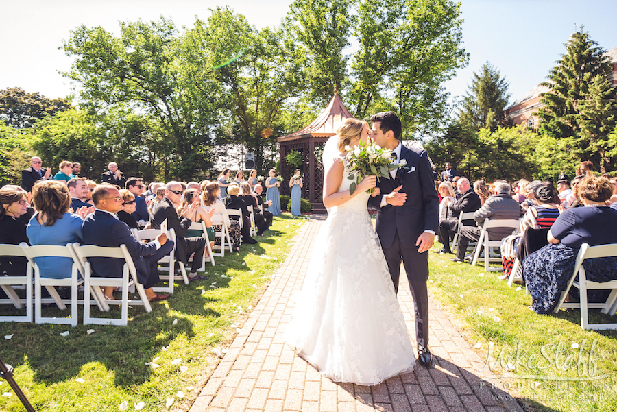 bride and groom kissing end of aisle outside ceremony