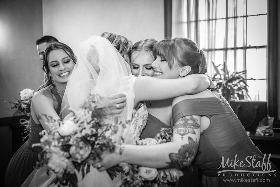 bride hugging bridesmaids